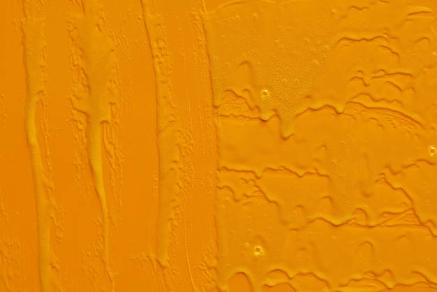 Cream liquid gel serum flowing down on yellow texture
