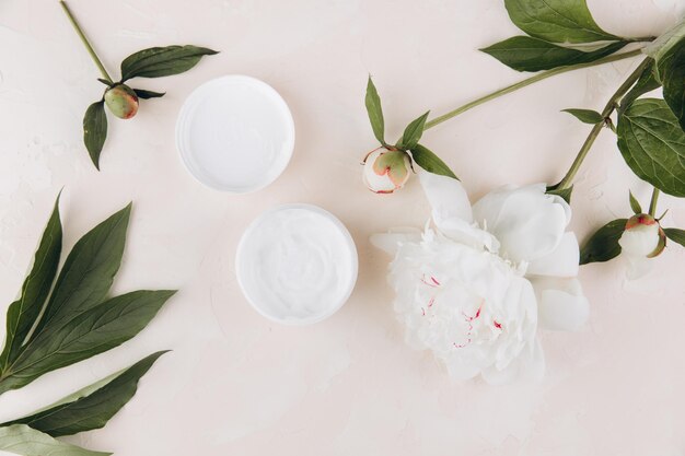 A cream mask on a light background with a delicate peony flower Mock up image