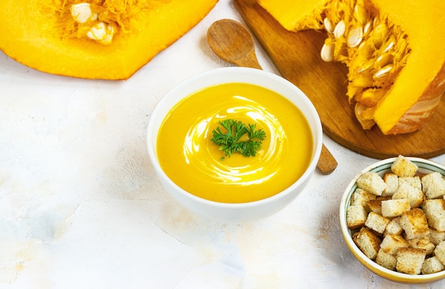 Foto crema di zucca su un tavolo leggero crema di zucca su un tavolo luminoso con crostini di pane.