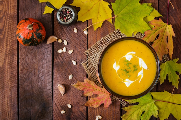 Cream of pumpkin soup with sour cream sauce. Halloween. Top view