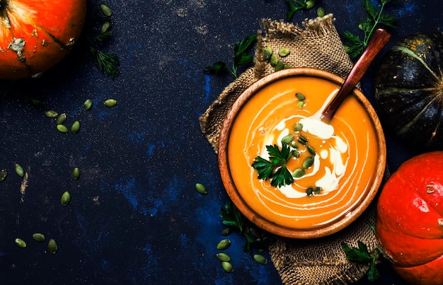 Cream pumpkin soup in a wooden bowl rustic style top view