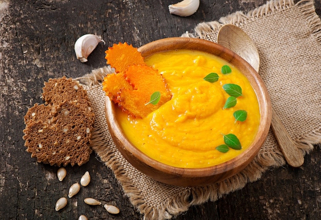 Cream of pumpkin soup in a wooden bowl