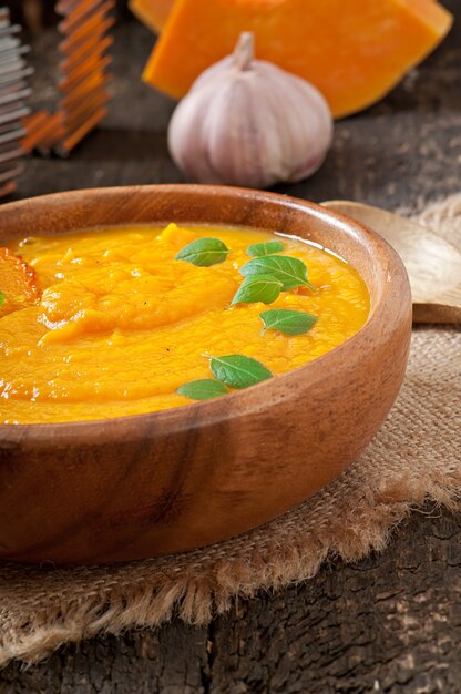 Cream of pumpkin soup in a wooden bowl