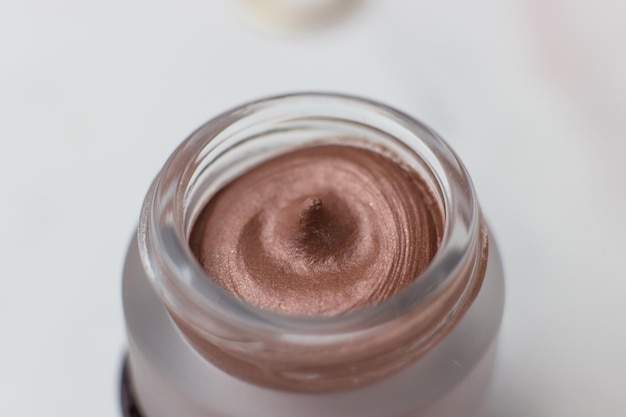 Cream shadows in a round jar on a white background