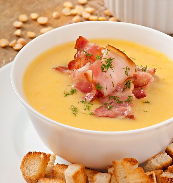 Cream soup of peas with fried bacon and croutons