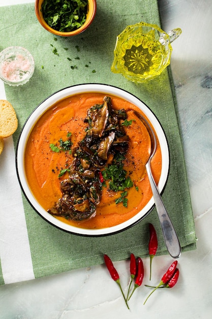 Cream soup of red lentils with tomatoes and fried wild mushrooms on the table healthy vegan warming food for the whole family