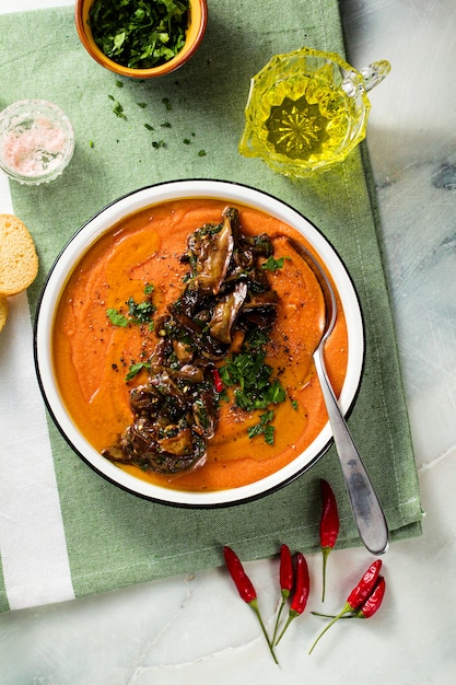 Крем-суп из красной чечевицы с помидорами и жареными грибами на столе. здоровая веганская пища для всей семьи