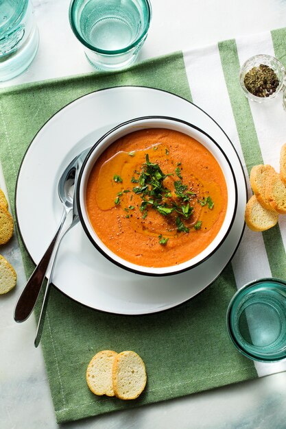 テーブルの上のトマトと赤レンズ豆のクリームスープ。家族全員のための健康なビーガン温暖化食品