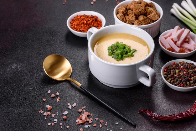 Крем-суп с картофелем, луком-пореем и горошком на темном бетонном столе