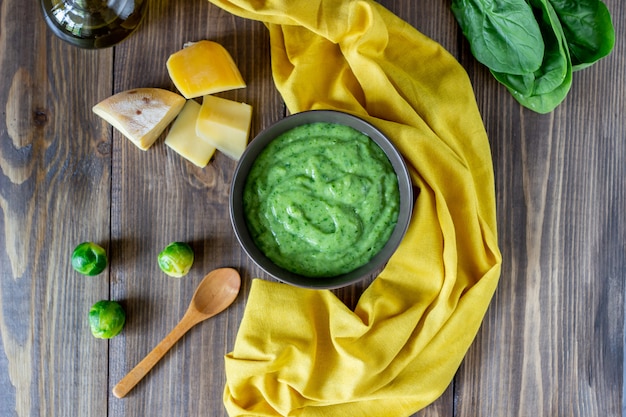 Zuppa di crema con spinaci e formaggio superficie in legno