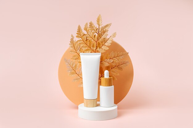 Photo cream tube mockup and  dropper on podium with leaf