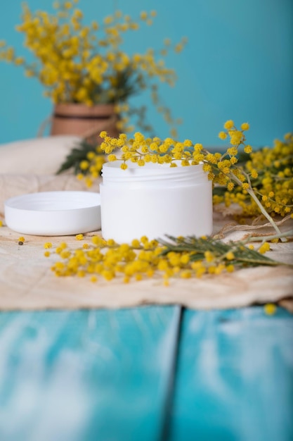 Cream with mimosa extract on a wooden surface. Closeup