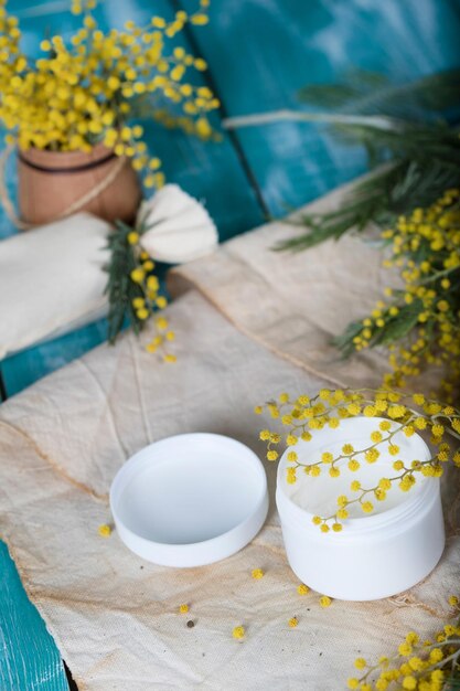 Cream with mimosa extract on a wooden surface. Closeup