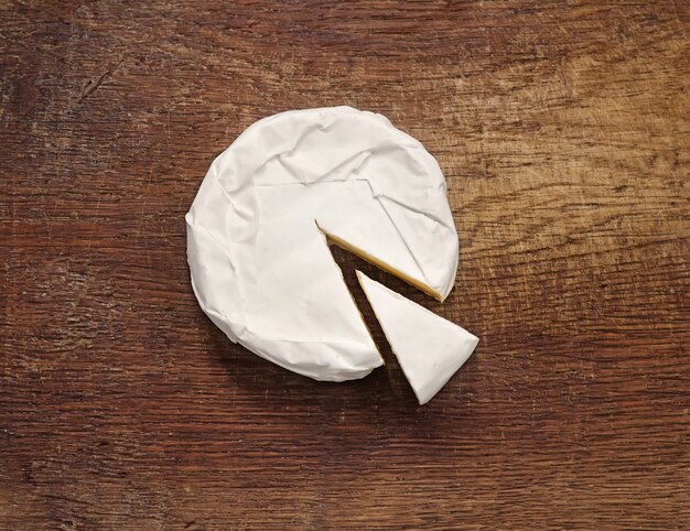 Photo creamy brie on rustic wooden background, top view