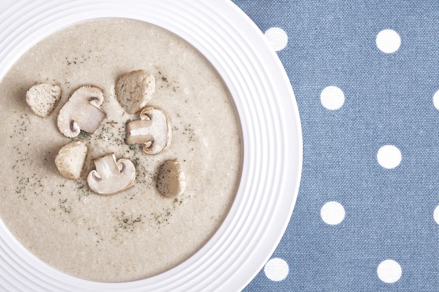 Foto zuppa di pollo cremosa con funghi su un piatto bianco.