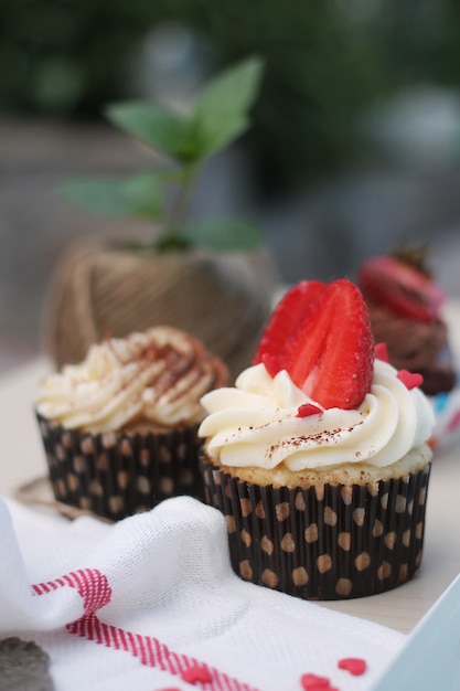 Creamy cupcakes decorated with strawberry and sugar heart