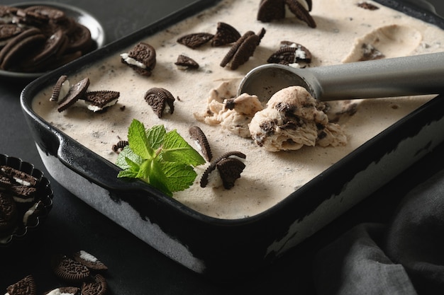 Creamy ice cream with chocolate cookies in container tasty dessert without sugar