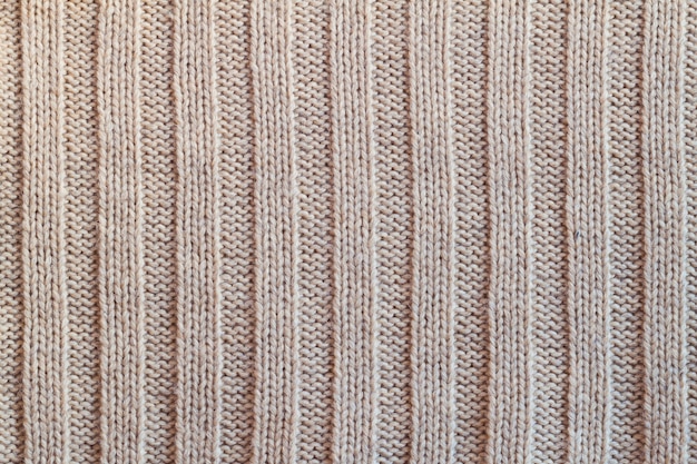 Creamy knitted wool warm clothes for the winter fabric texture background