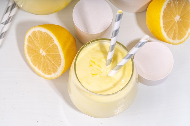 Creamy lemon fruit smoothie yogurt ar milkshake Sour sweet drink with fresh lemons on white yellow background copy space