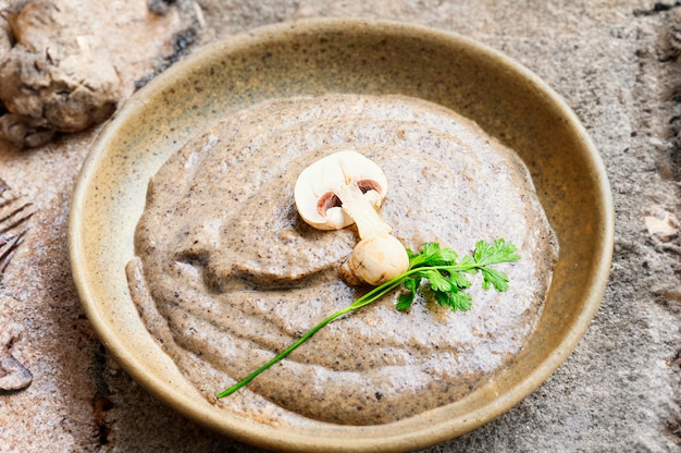 Creamy mushroom soup puree on rustic table