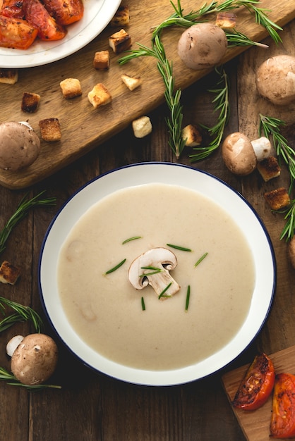 creamy mushroom soup on wood with champignons mushrooms 