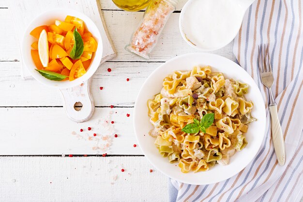 Pasta cremosa con pollo e melanzane servita nel piatto fondo.