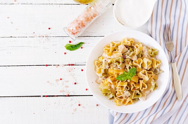 Creamy pasta with chicken and eggplant  served in deep plate.