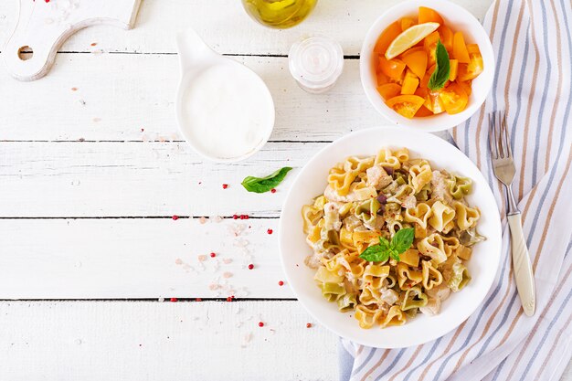 Creamy pasta with chicken and eggplant  served in deep plate.