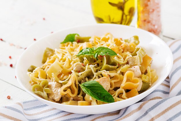 Pasta cremosa con pollo e melanzane servita nel piatto fondo.