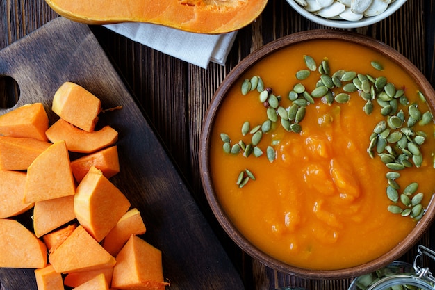 Creamy pumpkin soup on a brown wooden table