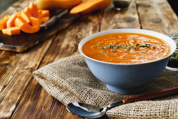 Creamy pumpkin soup on a brown wooden table