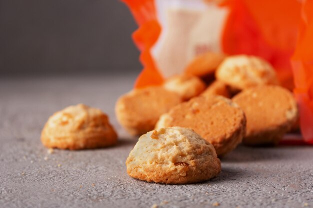 Creamy round biscuits pouring out of the package copy space close up