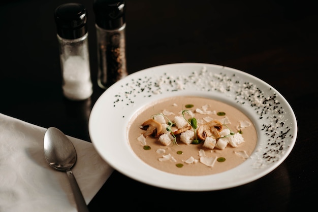 Creamy soup with mushrooms and croutons on the table