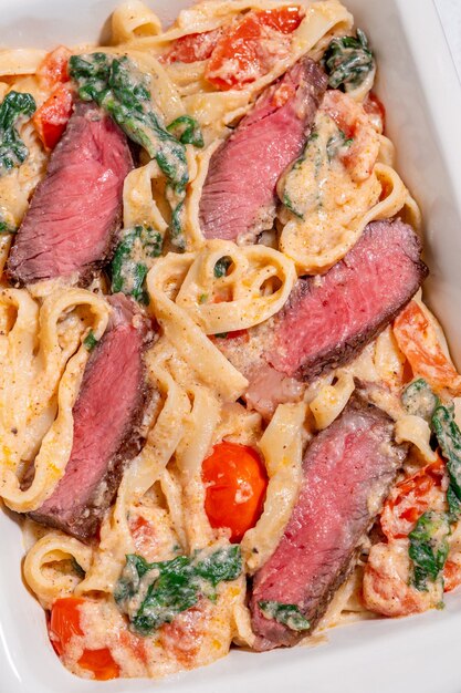 Creamy steak fettuccine pasta with spinach and tomatoes