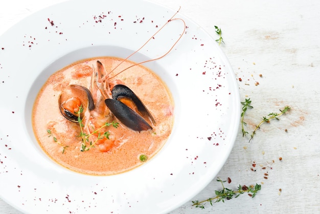 Creamy tomato soup of seafood. Shrimps, mussels, squid. Top view. Free copy space.