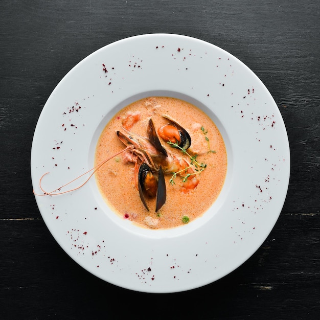 Creamy tomato soup of seafood. Shrimps, mussels, squid. Top view. Free copy space.