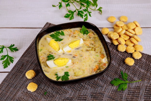 Creamy vegetable soup with egg and crackers