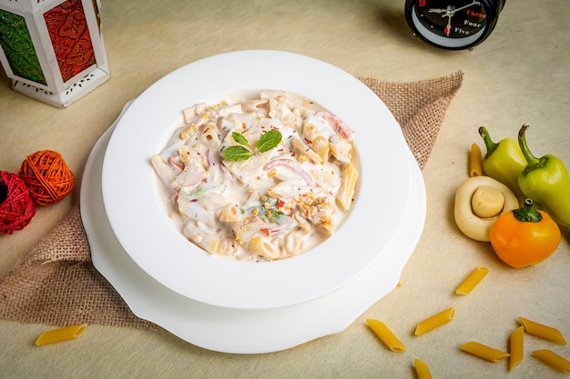 Creamy white dipped pasta in a plate side view on wooden background