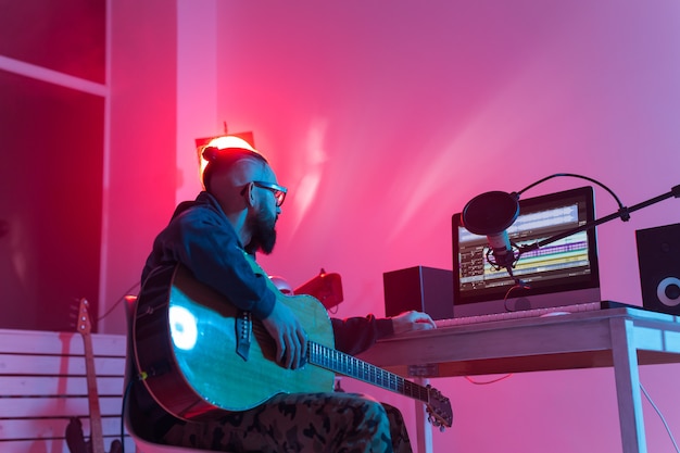 Create music and a recording studio concept - Bearded funny man guitarist recording electric guitar