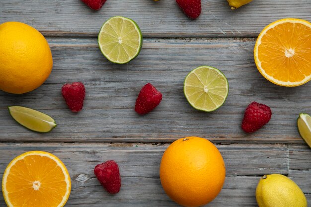 Creatief fruit plat lag oranje limoen en framboos op de houten achtergrond