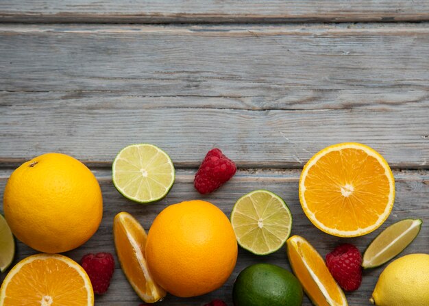 Creatief fruit plat lag oranje limoen en framboos op de houten achtergrond