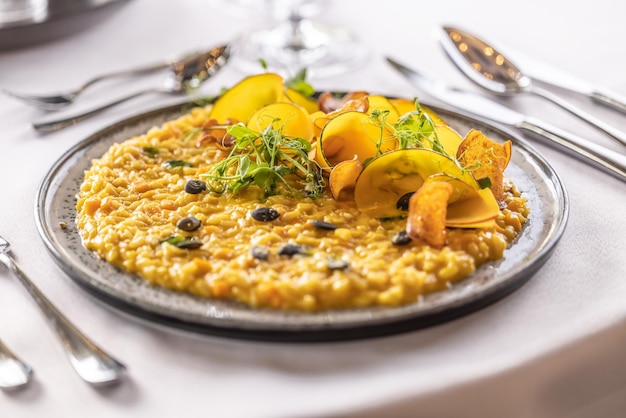 Creatief gekookte pompoenrisotto geserveerd op een ceremonieel voorbereide tafel in het restaurant van het hotel