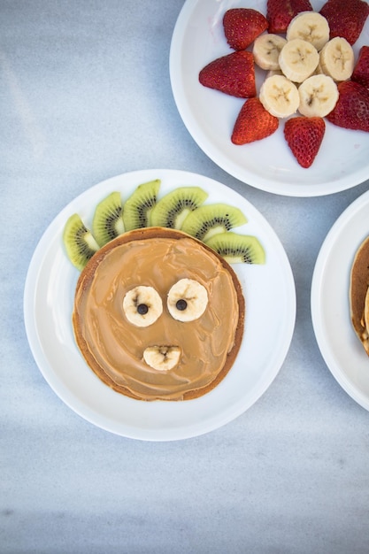 Creatief idee voor kinderontbijt Beervormige pannenkoeken met bessen op marmeren tafelblad Gezond eten voor kinderen Grappig eten voor kinderen