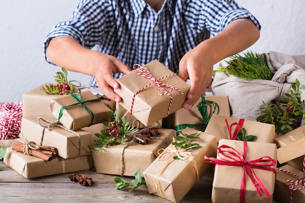 Creatief kerstconcept zonder afval, schattige jongen die geschenken inpakt