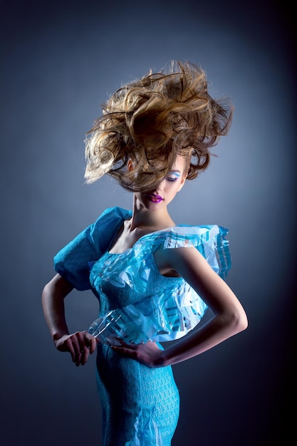 Creatief model poseert in een blauwe jurk