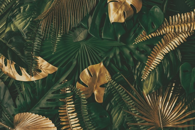 Creatieve aardachtergrond goud en groen tropisch monstera en palmbladeren minimale zomerabstrac