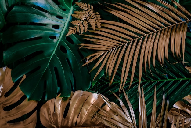 Creatieve aardachtergrond goud en groen tropisch monstera en palmbladeren minimale zomerabstrac