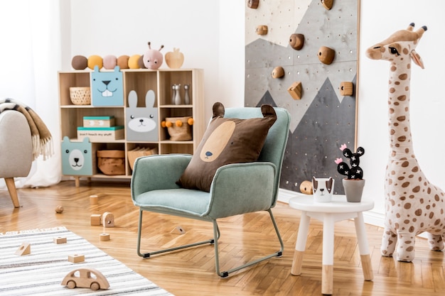 Creatieve compositie van stijlvolle en gezellige kinderkamer interieur met pluchen speelgoed sofa commode fauteuil tapijt en accessoires