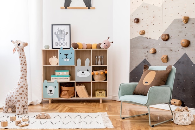 Creatieve compositie van stijlvolle en gezellige kinderkamer interieur met pluchen speelgoed sofa commode fauteuil tapijt en accessoires