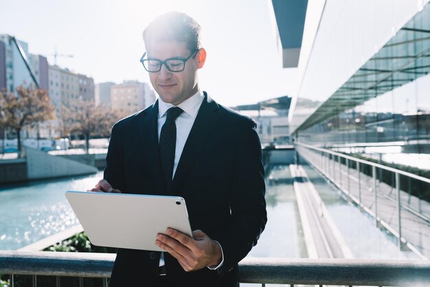 Creatieve formele man aan het werk op tablet in zonlicht